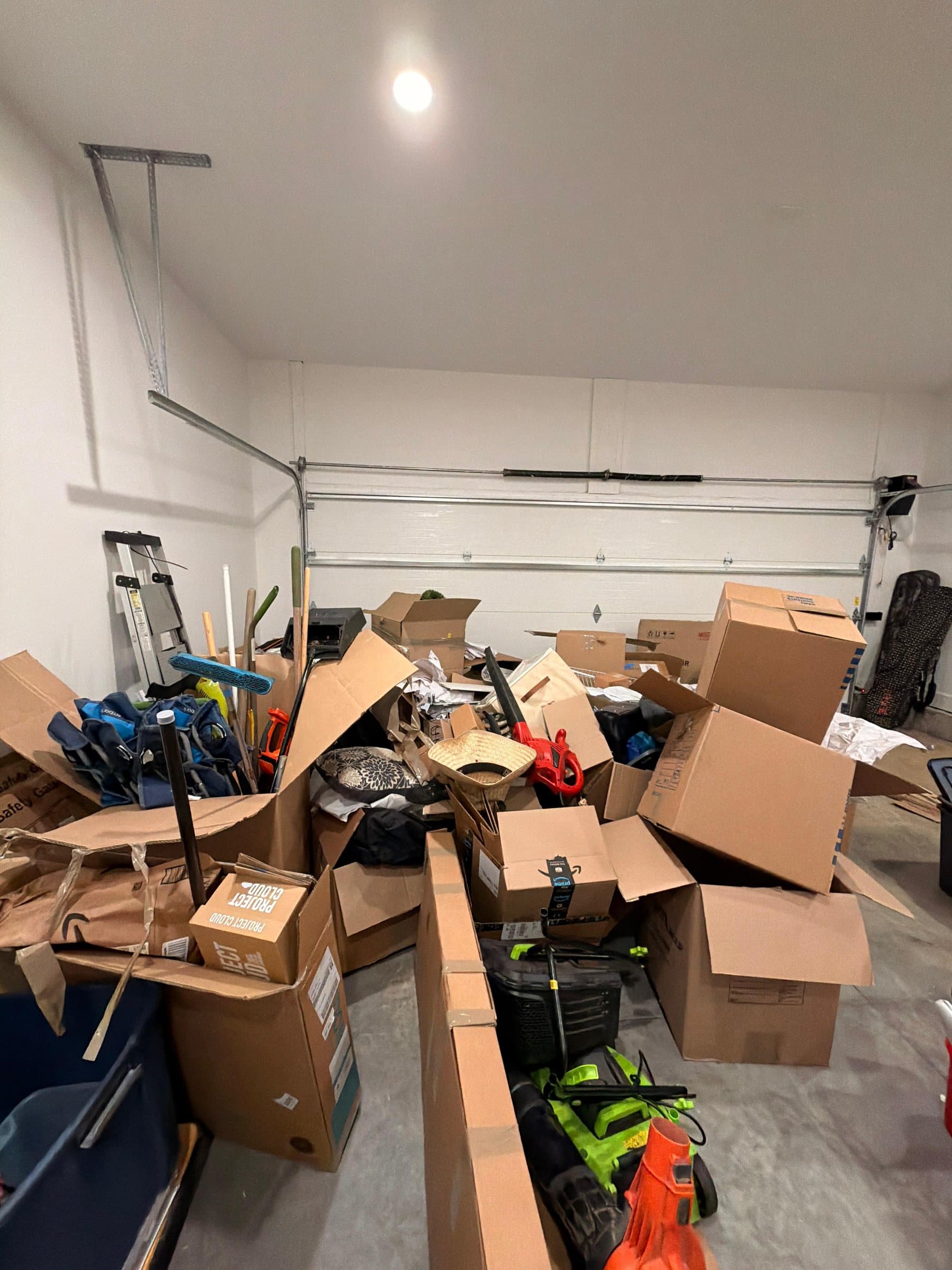 A two-car garage packed floor to ceiling with boxes, tools and bags before Clean Trail arrived